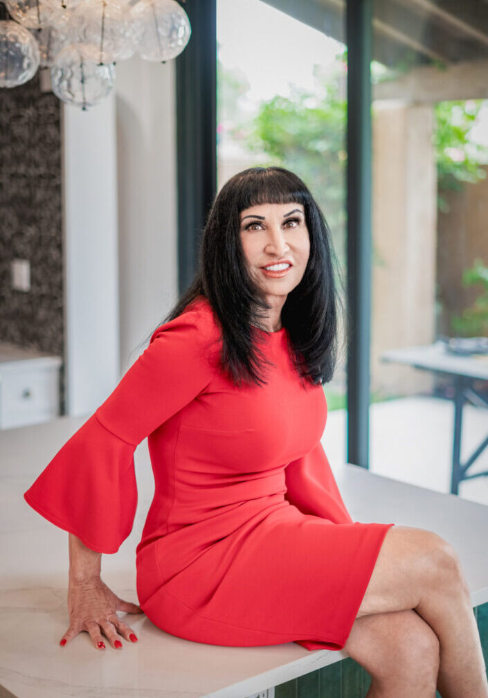 Smiling woman in red dress on countertop